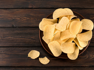 chips in a plate on a wooden background