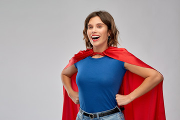 women's power and people concept - happy woman in red superhero cape over grey background © Syda Productions