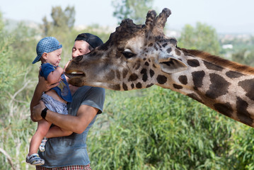 Father with son watching giraffe in the zoo © Elina Leonova