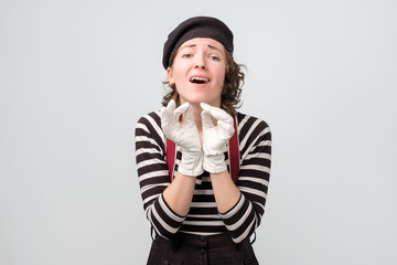 Beautiful french female mime smiling being excited. ositive facial human emotion. Studio shot