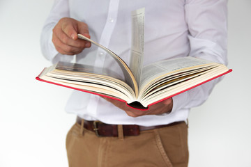 A man holds a big red book in his hands. Business concept isolated on white background.