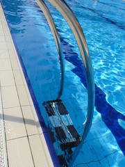 Swimming pool ladder.  Blue spa swimming pool with  blu clean water, outdoor, rubber anti-slip flooring.
