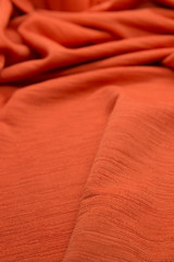 This is a photograph of textured neon Orange fabric background
