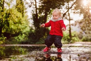 kleinkind spielt in Regenpf&uuml;tze