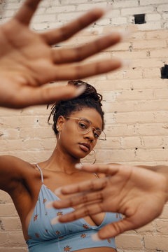 Portrait of young woman blocking camera with hands