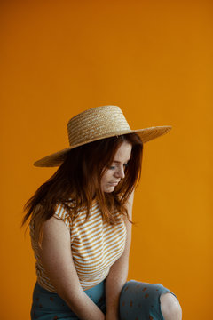 Redhaired woman wearing a straw hat