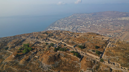 Aerial drone photo of iconic archaeological site of ancient Thera or Thira built uphill with...