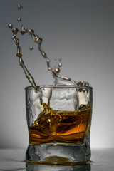 Whiskey squirts from the glass