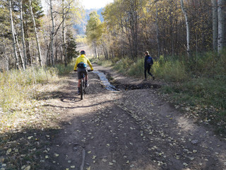 Obraz premium Asian man riding a bike and caucasian woman walking at Sardine Peak Trailhead