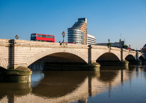  Putney bridge reflected in Thames river water in a sunny day - London, England