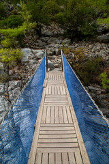 Obraz premium pedestrian bridge over the river in the mountains