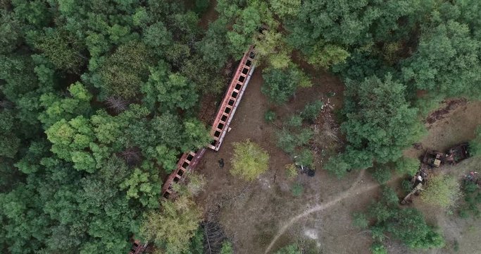 Ruined Yanov station in the city of Pripyat in the exclusion zone where cars are lying on their side in the forest aerial photography