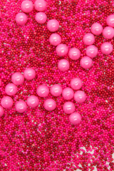 This is a photograph of Pink round sprinkles isolated on a White background