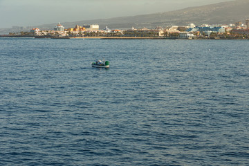Las Americas, Tenerife, Spain - May 25, 2019: View to the coastline and small fishing boat from the ferry departing for the island of La Gomera early morning from the port of Los Cristianos