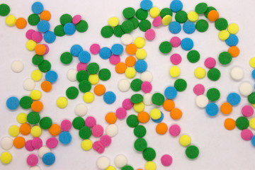 This is a photograph of colorful round sprinkles isolated on a White Background