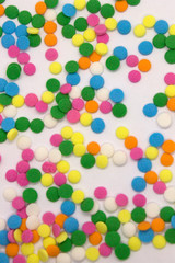 This is a photograph of colorful round sprinkles isolated on a White Background