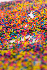 Fototapeta na wymiar This is a background of colorful neon colored round sprinkles background
