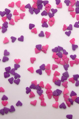 This is a photograph of Pink and Purple heart sprinkles isolated on a White background