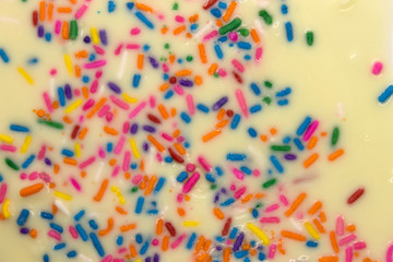 Fototapeta na wymiar This is a photograph of White chocolate topped with colorful sprinkles