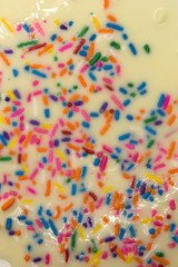 Fototapeta na wymiar This is a photograph of White chocolate topped with colorful sprinkles