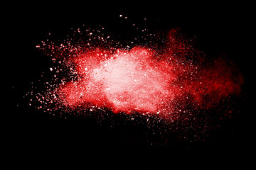 Red powder explosion on black background. Paint Holi.