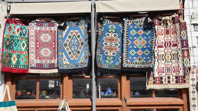 Souvenir shop on the street in Gjirokaster, Albania. Traditional market. Bazaar in old town. Traditionally and hand made objects, instruments, carpet, items, hats.