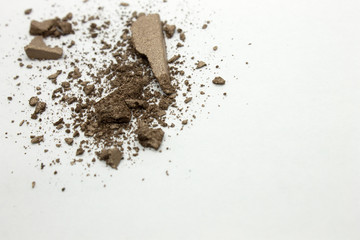 This is a photograph of a dark Bronze metallic powder eyeshadow isolated on a White background