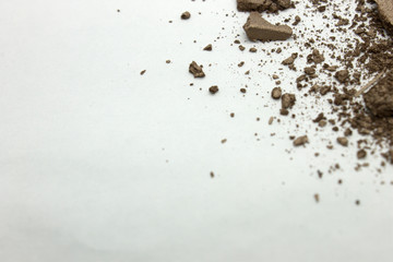 This is a photograph of a dark Bronze metallic powder eyeshadow isolated on a White background