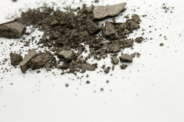 This is a photograph of a shimmery greyish Brown powder eyeshadow isolated on a White background