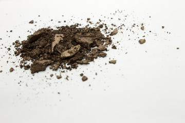 This is a photograph of a Deep Brown shimmery powder Eyeshadow isolated on a White background