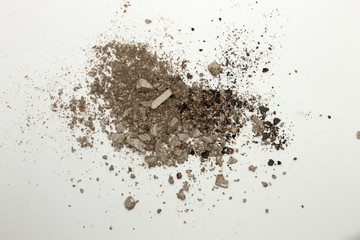 This is a photograph of a Greyish Brown powder Eyeshadow isolated on a White background