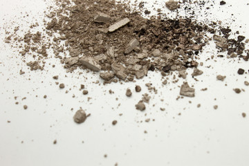 This is a photograph of a Greyish Brown powder Eyeshadow isolated on a White background