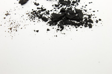 This is a photograph of a Black powder Eyeshadow isolated on a White background