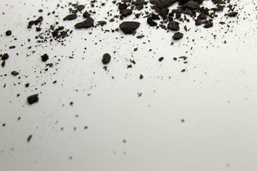 This is a photograph of a Dark Brown powder eyeshadow isolated on a White background
