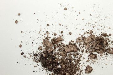 This is a photograph of a light Brown powder eyeshadow isolated on a White background