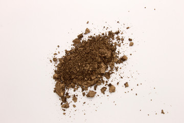 This is a photograph of a Brown powder eyeshadow isolated on a White background