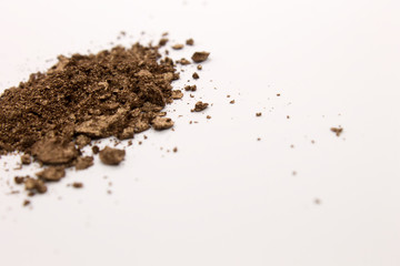 This is a photograph of a Brown powder eyeshadow isolated on a White background