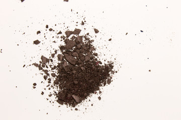This is a photograph of a dark Brown powder Eyeshadow isolated on a White background