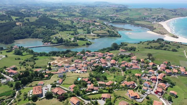 Aerial panoramic view of summer landscape overlooking small Spanish town of Comillas on coast of Cantabrian Sea