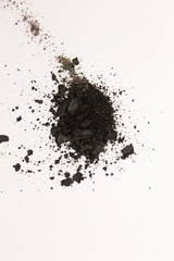 This is a photograph of Black powder Eyeshadow isolated on a White background