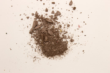 This is a photograph of deep Taupe powder Eyeshadow isolated on a White background