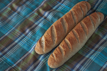 Baguette bread on a wooden table cloth.