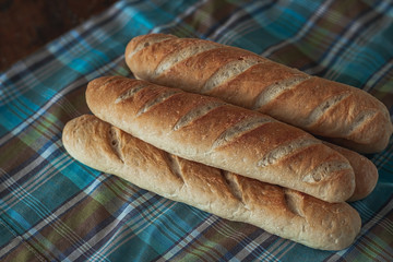 Baguette bread on a wooden table cloth.