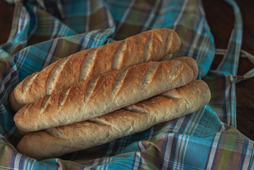 Baguette bread on a wooden table cloth.
