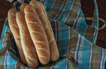Baguette bread on a wooden table cloth.