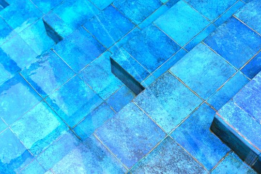 Overhead closeup of blue, stone stairs in a pool with water