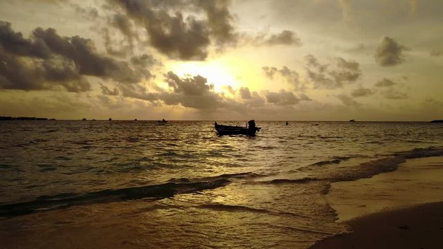 Retro style wallpaper with a fishing boat waiting near shore on a golden sunset background in Pulau Biola, Singapore