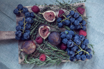 An edible display tray of fruit and garnishes on a wooden chopping block 