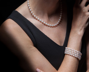 Wealthy well dressed rich privileged white Caucasian woman adorns her prized natural pearls...