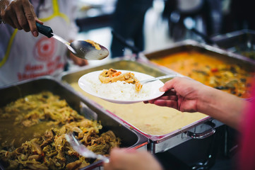 Volunteers donate food to those who need food to alleviate hunger, the poor receive charity food...